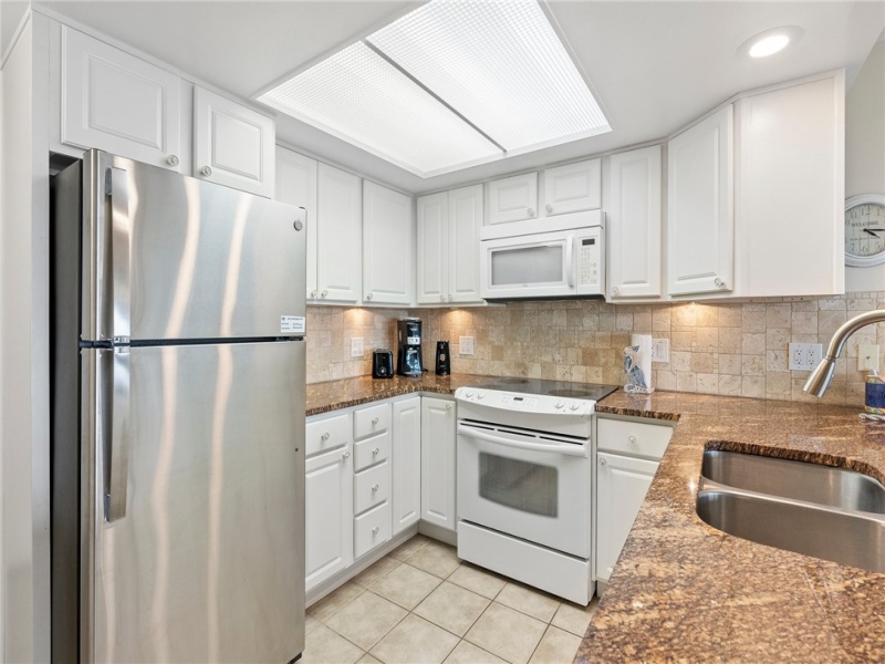 Spacious granite countertops with plenty of cabinets for storage.