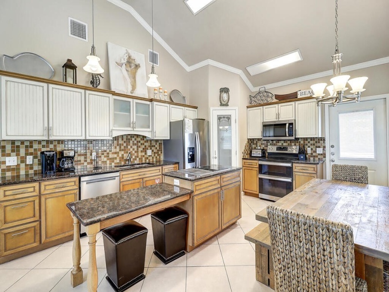 Kitchen with lots of granite, stainless steel appliances, and pantry closet