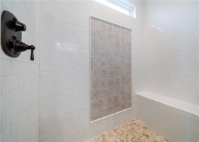 Primary shower w tile accent wall & river rock floor.