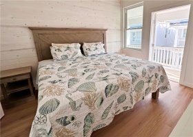 Primary bedroom with beach armoire and outside patio