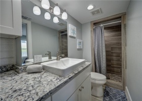 Guest bathroom offers granite countertops and walk-in shower.