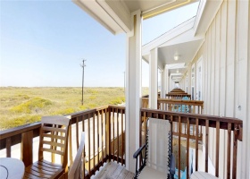 Balcony with seating and views of Lake Padre to the left and distant view of beach to the right.