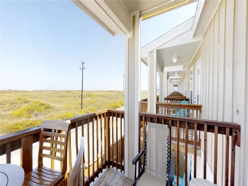 Balcony with seating and views of Lake Padre to the left and distant view of beach to the right.
