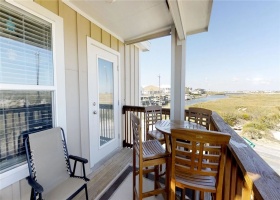 Balcony with seating and views of Lake Padre to the left and distant view of beach to the right.