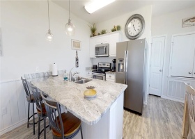 Large kitchen island with bar stools that opens to the living/dining space.