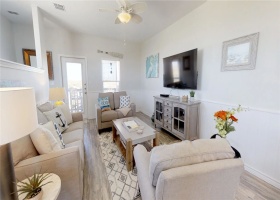 Open living are with comfortable seating, ceiling fan and large flat screen tv.