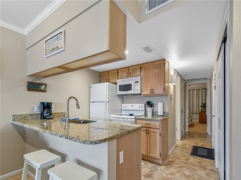Cute step-saver kitchen with granite counters and breakfast bar....