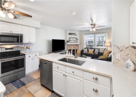 Kitchen is open to living area with extra seating at the counter.